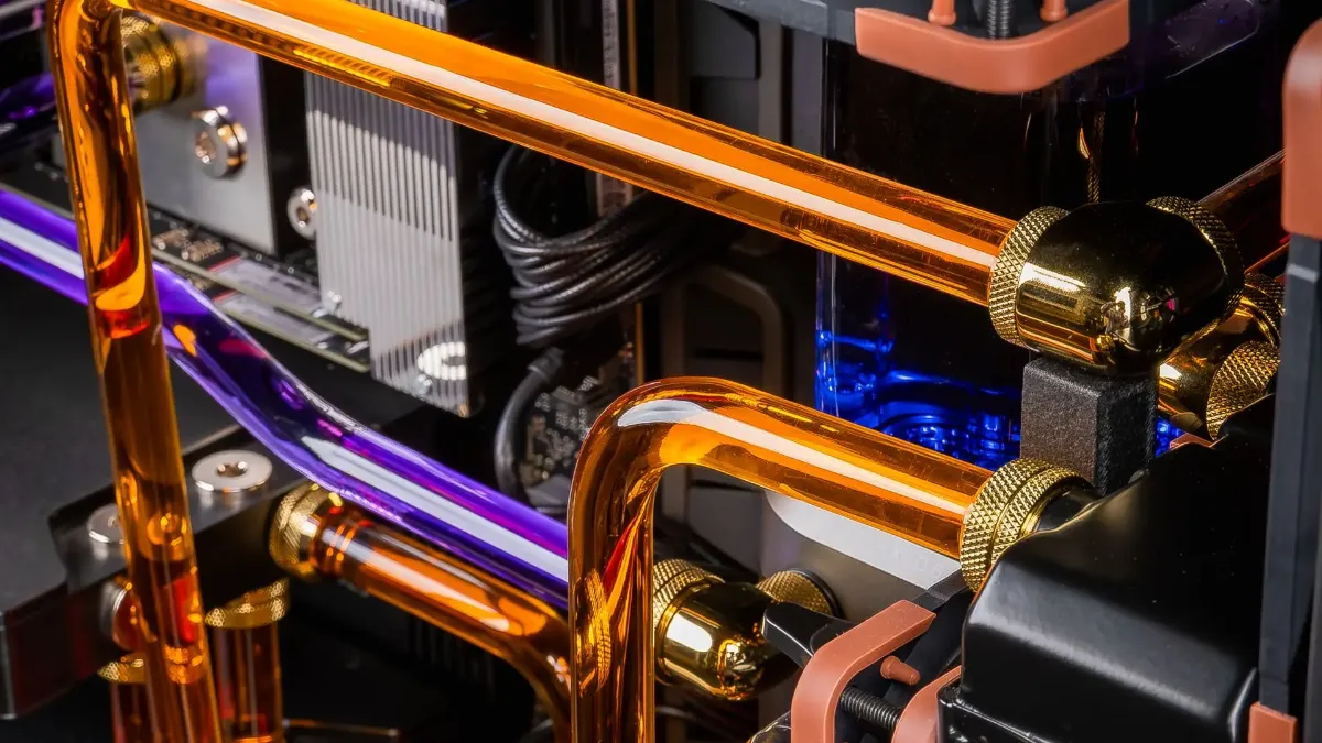 High-end gaming PC with custom water cooling, transparent rigid orange and violet tubes, RGB liquid cooling and premium components assembled to fit