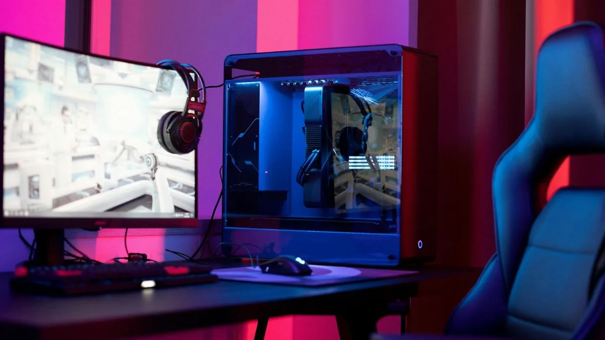 Gaming PC setup with monitor, headset and pink lighting