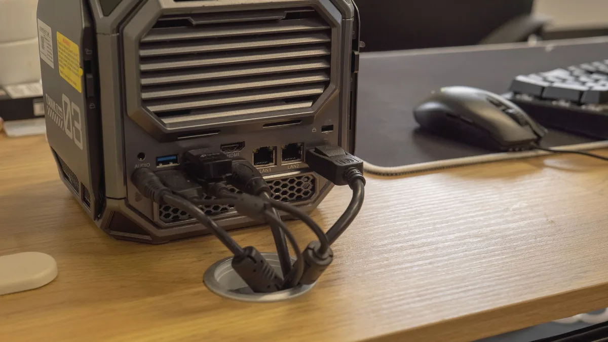 PC case placed on a wooden desk, cables connected at the back
