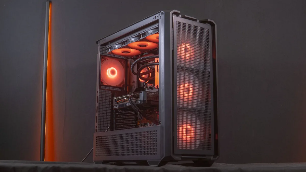 Black gaming PC case with orange fans placed on a hard surface