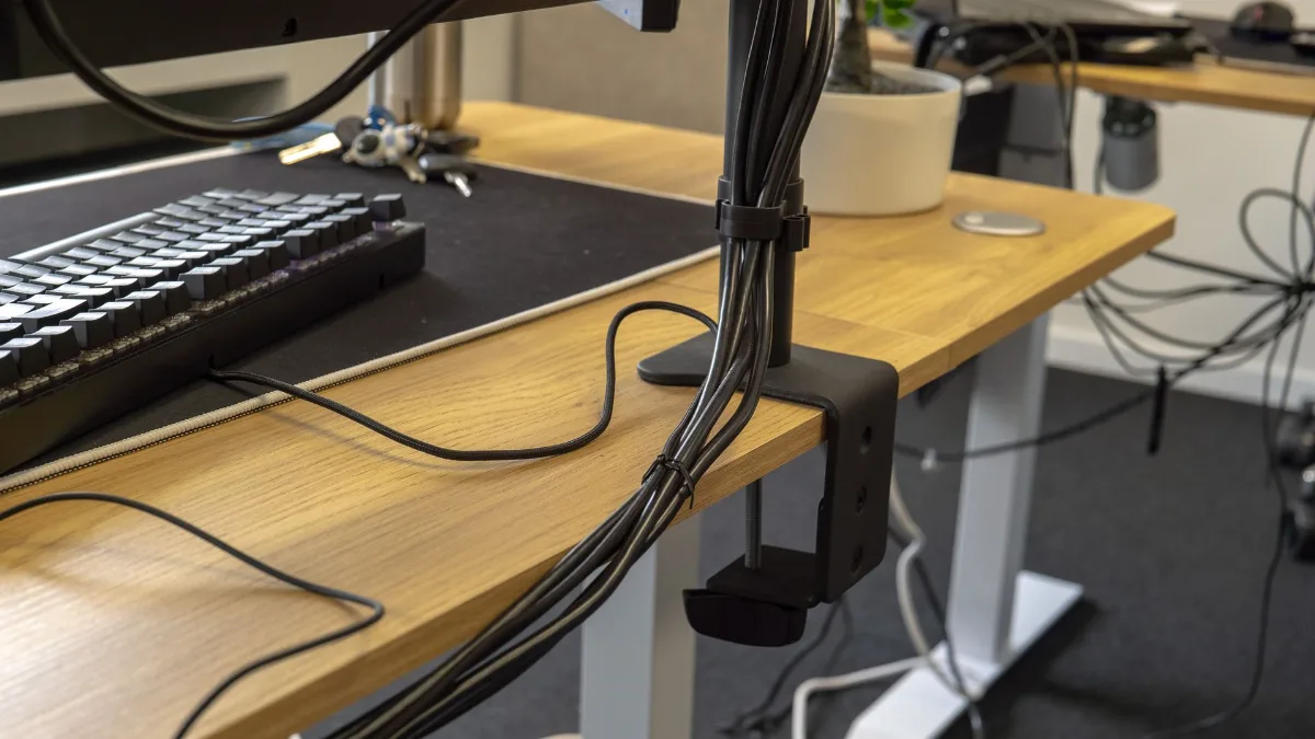 Pc-kabels netjes geleid langs een steun voor een opgeruimd bureau