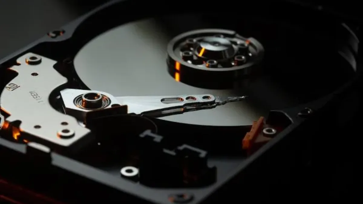 Disque dur HDD ouvert montrant le plateau magnétique et la tête de lecture