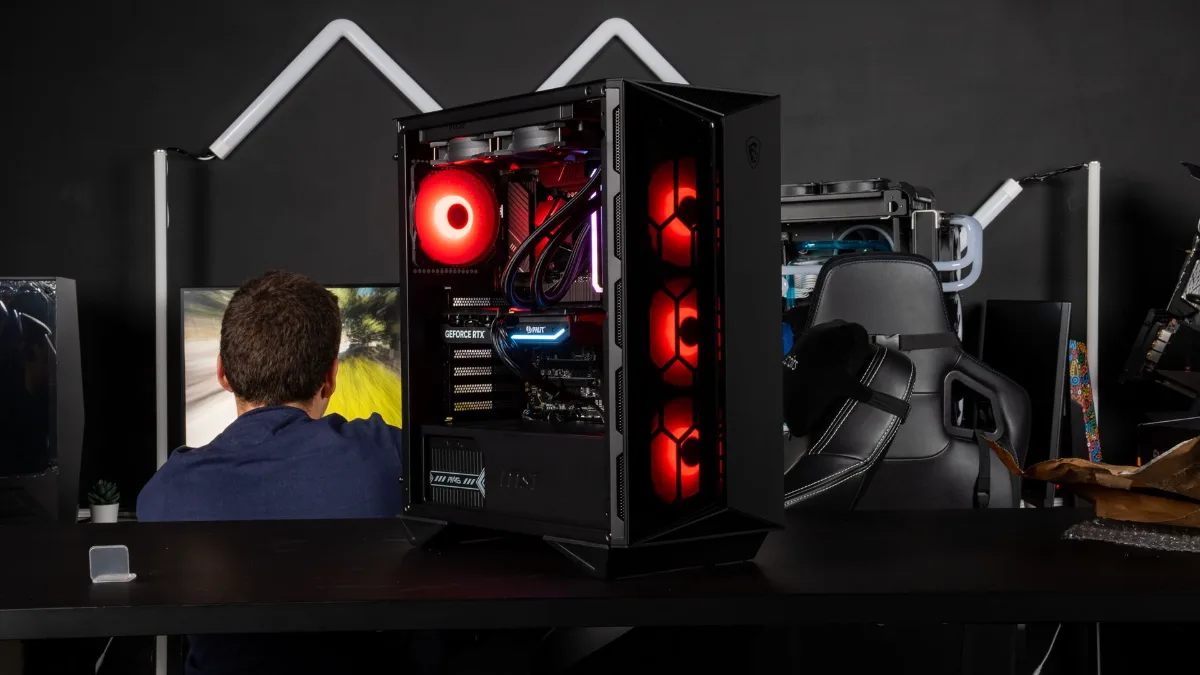 A player seated at their desk in front of a FlowUP gaming PC