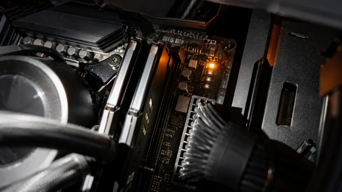 Gaming PC motherboard on a workbench with a diagnostic light switched on next to the RAM sticks