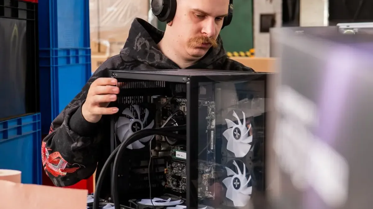 Technicien FlowUP installant une carte graphique dans un boîtier de PC gamer à l'atelier