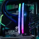 Gros plan sur les barrettes de RAM Corsair Vengeance DDR5 avec un éclairage ARGB dégradé, installées à côté du waterblock Cooler Master dans le PC gamer Aqua
