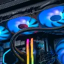 Gros plan sur les ventilateurs supérieurs rétroéclairés en bleu et les barrettes de RAM Corsair Vengeance du PC gamer Aqua, avec les tubes du système de refroidissement liquide