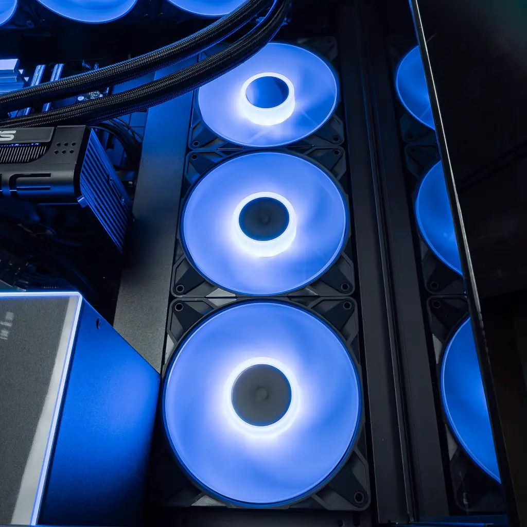 Trois ventilateurs de boîtier avec anneaux LED violets installés verticalement dans le PC gamer Cheetoh Remastered