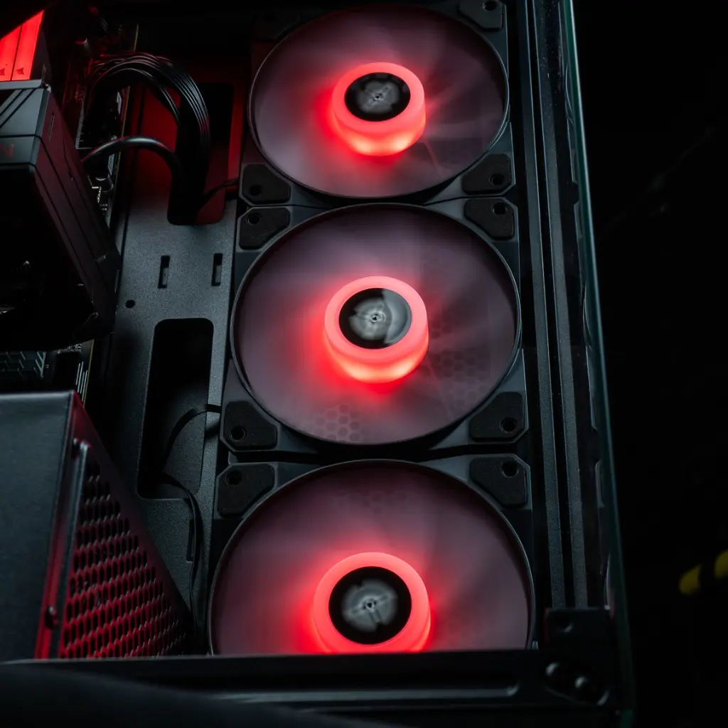 Vue rapprochée des trois ventilateurs de façade ARGB du PC gamer Rift RX 9060 XT, éclairés d'un rouge intense