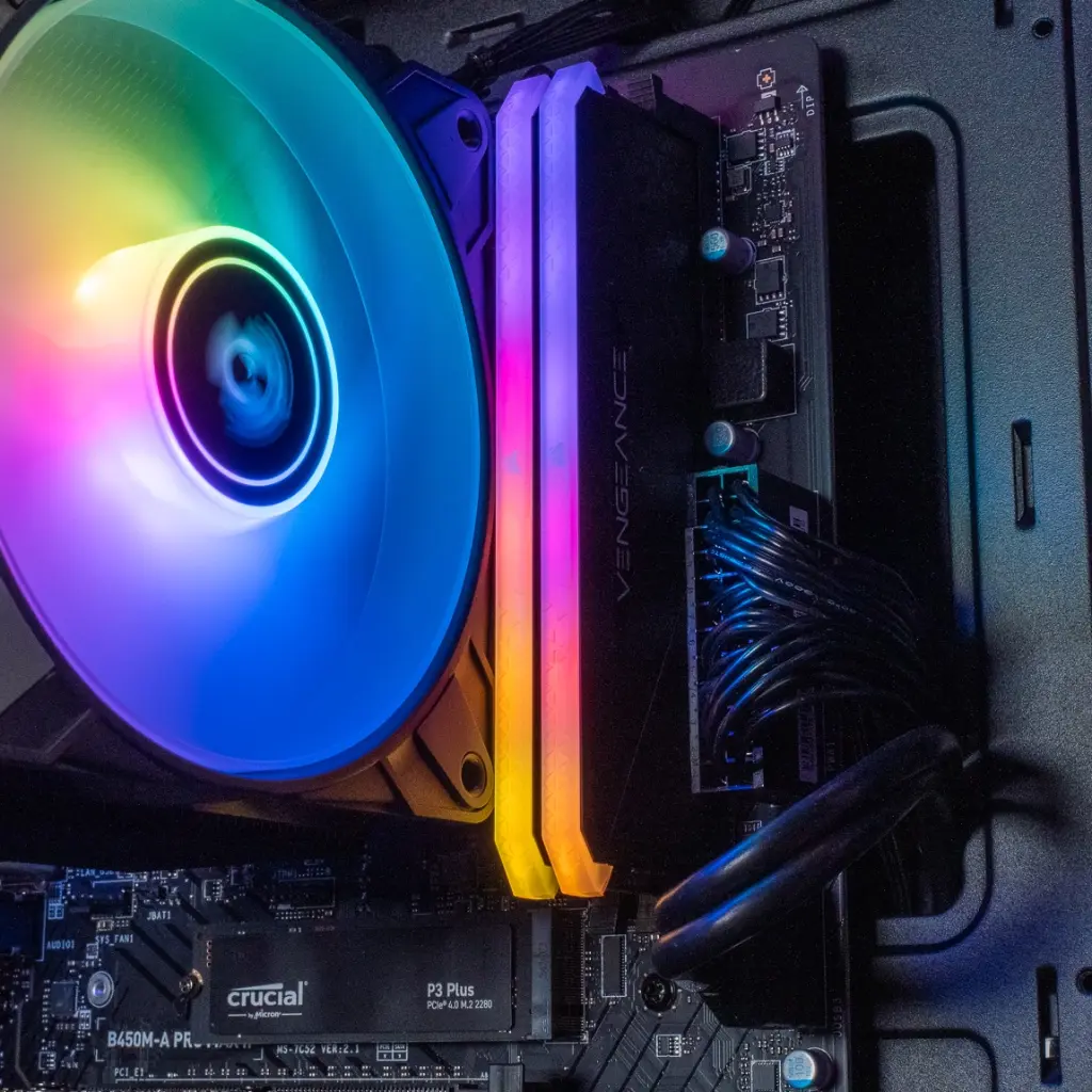 Détail des barrettes de RAM Corsair Vengeance RGB et du SSD Crucial P3 Plus installés sur la carte mère du PC Typhoon