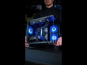 Un technicien de FlowUP présente le PC gamer Nightwing, mettant en avant son boîtier panoramique noir et son éclairage LED bleu dynamique
